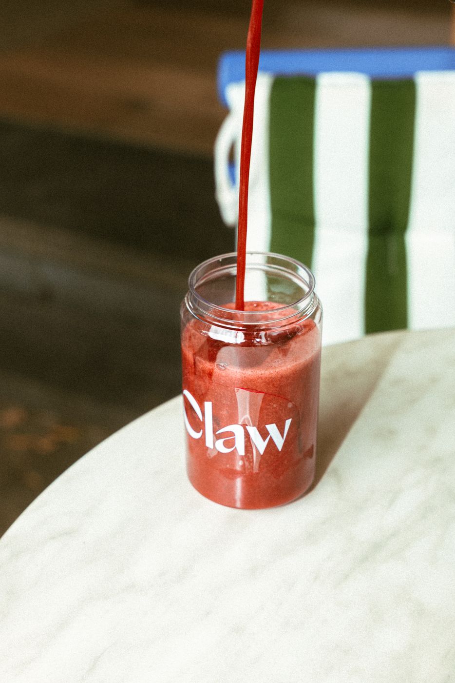 Red berry juice poured into a Claw jar