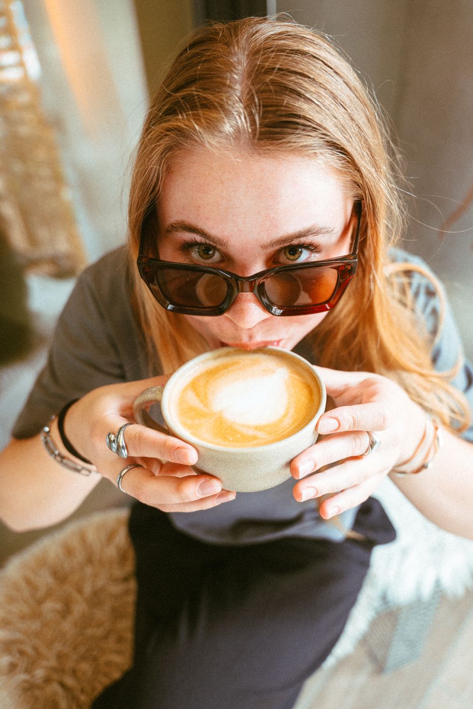 A guest in sunglasses drinking a cappuccino