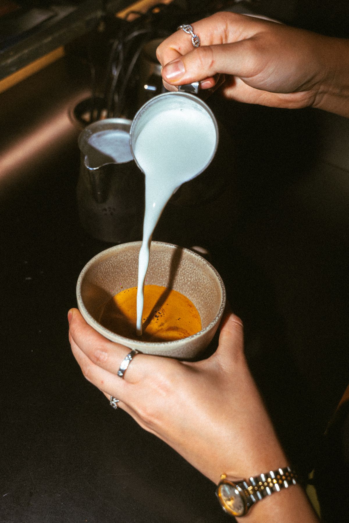 Milk poured into a cup of espresso